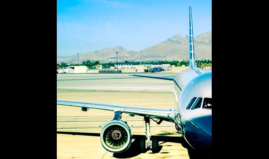 A closeup view of a jet plane sitting at a gate, ready to be loaded.