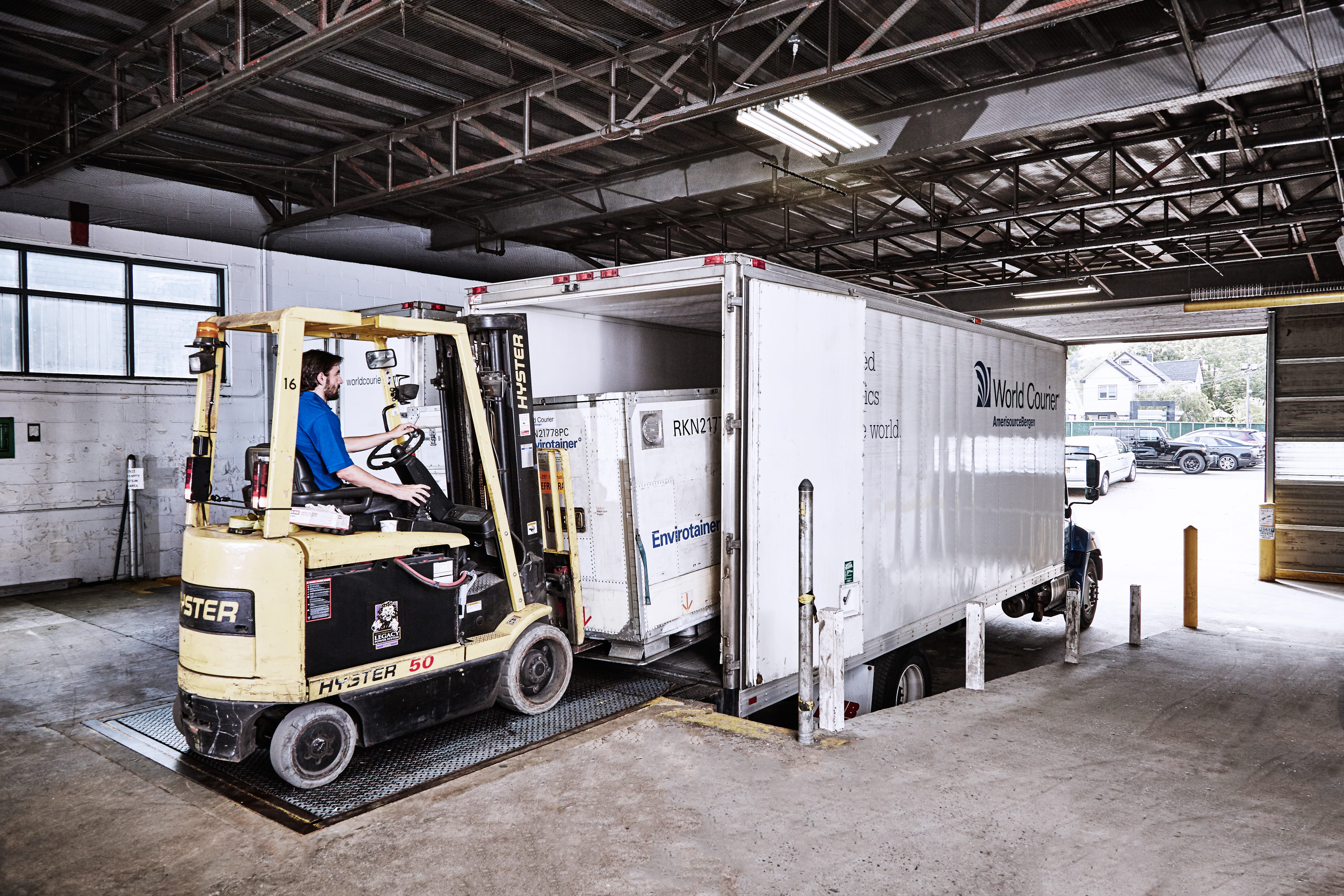 World Courier delivery truck being loaded by a forklift on a loading dock.