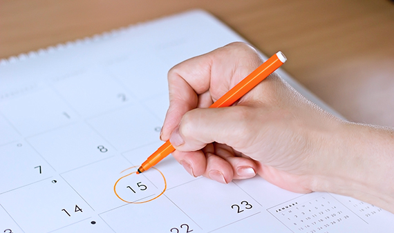 person circling date on calendar