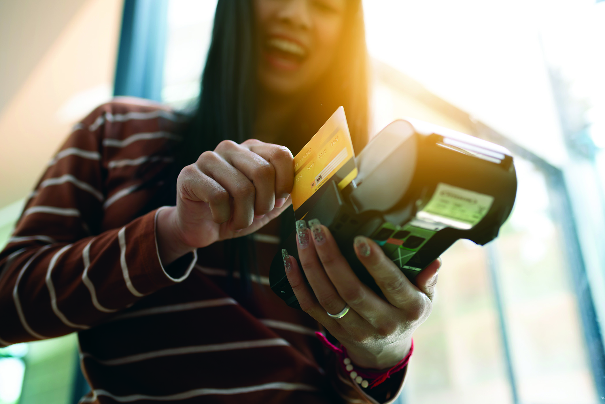 Millennial swiping her debit card to make a purchase